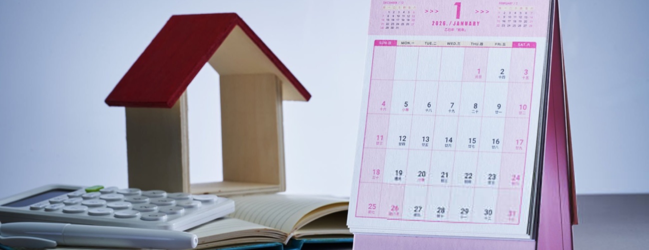 desk calendar 2026 with small house model and calculator as background