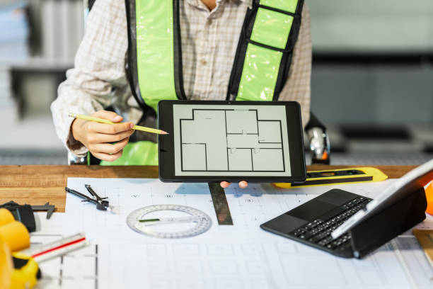 Female architect engineer is drafting blueprints using CAD software, focusing on sustainable infrastructure, renewable energy solutions, and adhering to building codes