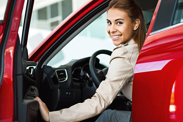 Photo of happy young mixed race woman sitting inside her new car. Concept for car rental
