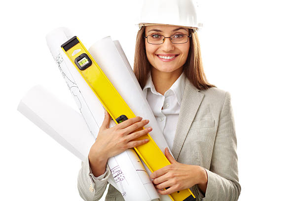 Portrait of smiling businesswoman in helmet holding rolled blueprints