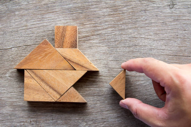Wooden tangram puzzle wait to fulfill home shape for build dream home or happy life concept