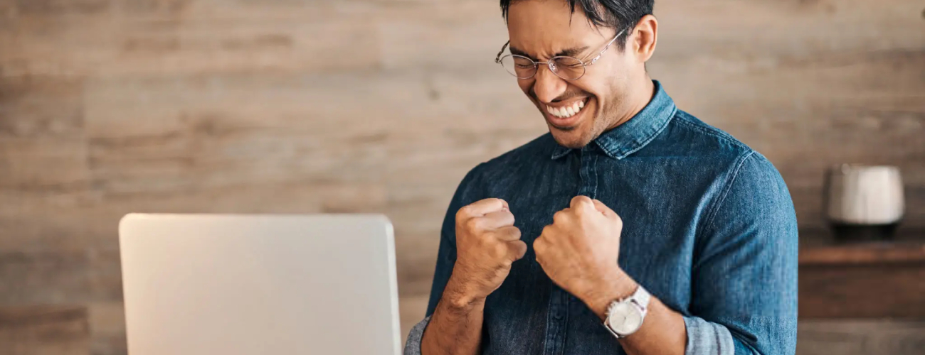 Success, winner and businessman on laptop with coffee celebrating winning, business deal or sales growth. Wow, entrepreneur or male from Canada in celebration of financial goals, mission or targets.