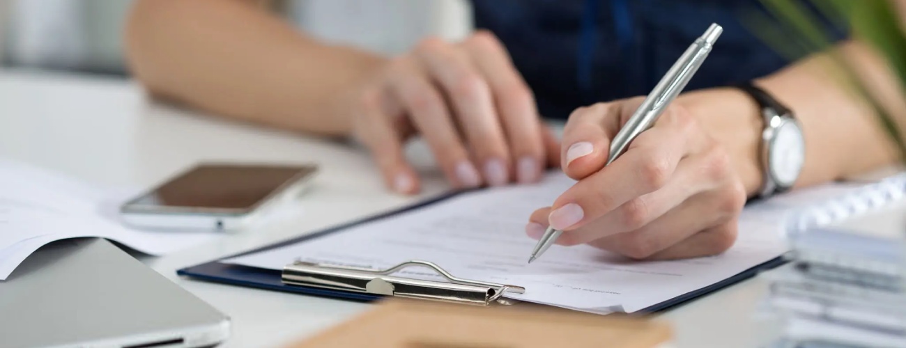 Close-up of female hands. Woman writing something sitting at her office