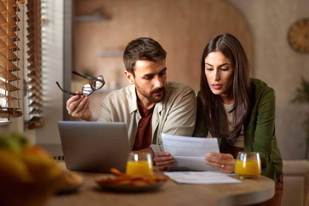 Young couple paying their bills over a computer at home.