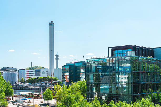 Modern buildings and the hammarby sjöstadsverk incineration plant tower rise above the green landscape of stockholm, sweden, on a sunny day