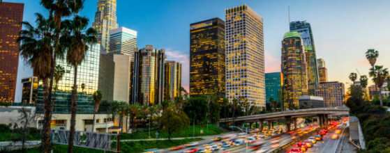 Traffic on Highway 110 in downtown Los Angeles. Skyline with office buildings and skyscrapers. Moody sky at dusk. California, USA.
