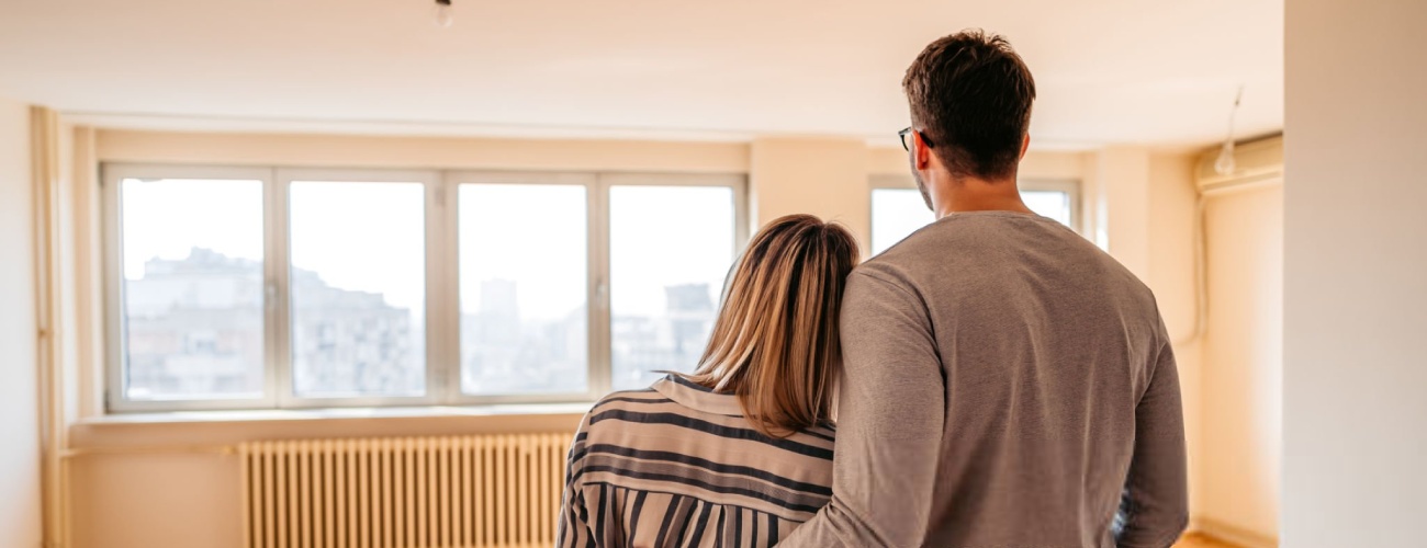Young loving heterosexual couple embracing in their new home.
