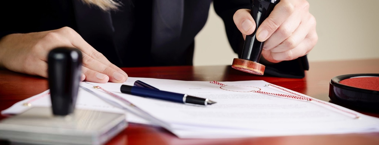 Closeup on notary's public hands stamping document. Notary public accessories