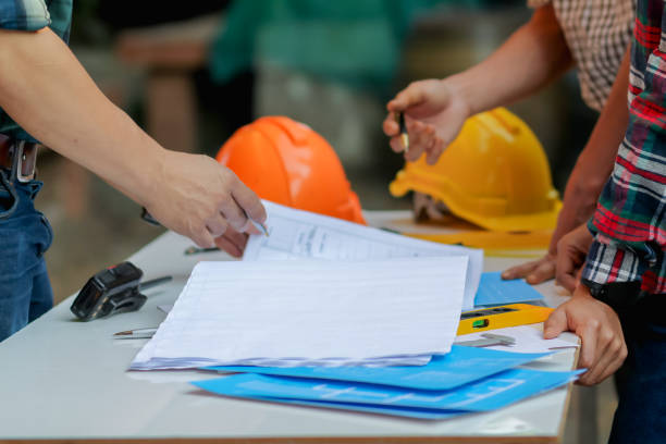 Blurred image, engineer is giving advice and consulting with the designer to find out construction site where engineer will have to construct the project. Consultation between engineers and designers