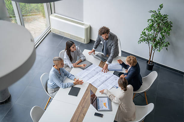 Group of architects examining blueprints during a productive meeting in a modern office space