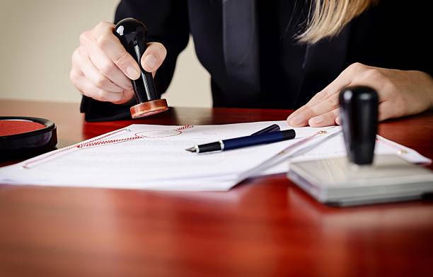 Closeup on notary's public hands stamping document. Notary public accessories