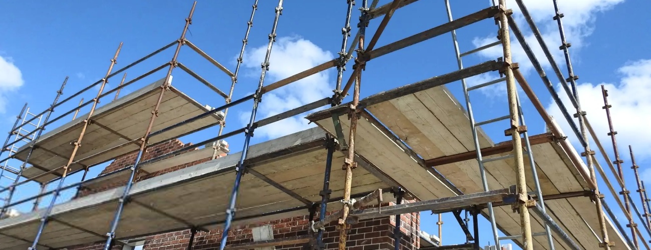 grok-image-ab52af73-db30-483b-82be-a63ed86fc5e0 Scaffolding around a partially built house on a housing construction site.