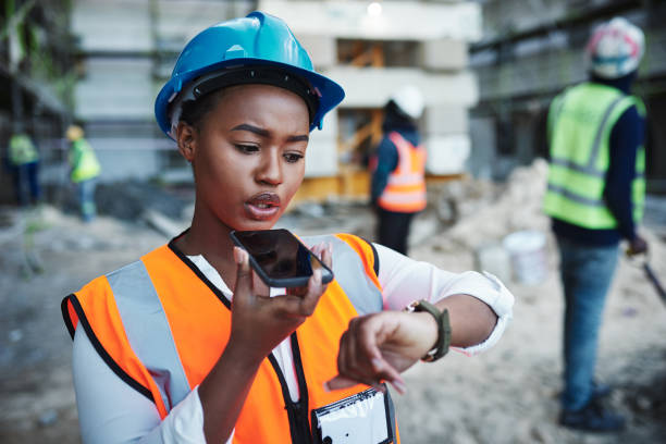 Shot of a young woman using a smartphone while working at a construction site