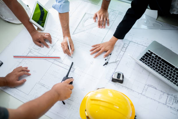 Team of engineers gathers for a meeting to discuss a new project. They collaborate, exchange ideas, and review plans, working together to create innovative solutions.