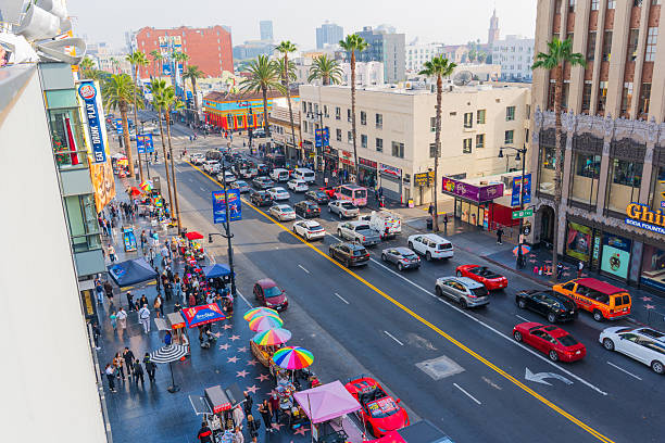 Los Angeles, California - December 23, 2024: Bustling view of Hollywood Boulevard featuring palm trees, traffic, and pedestrians enjoying the vibrant atmosphere on a sunny day in Los Angeles.