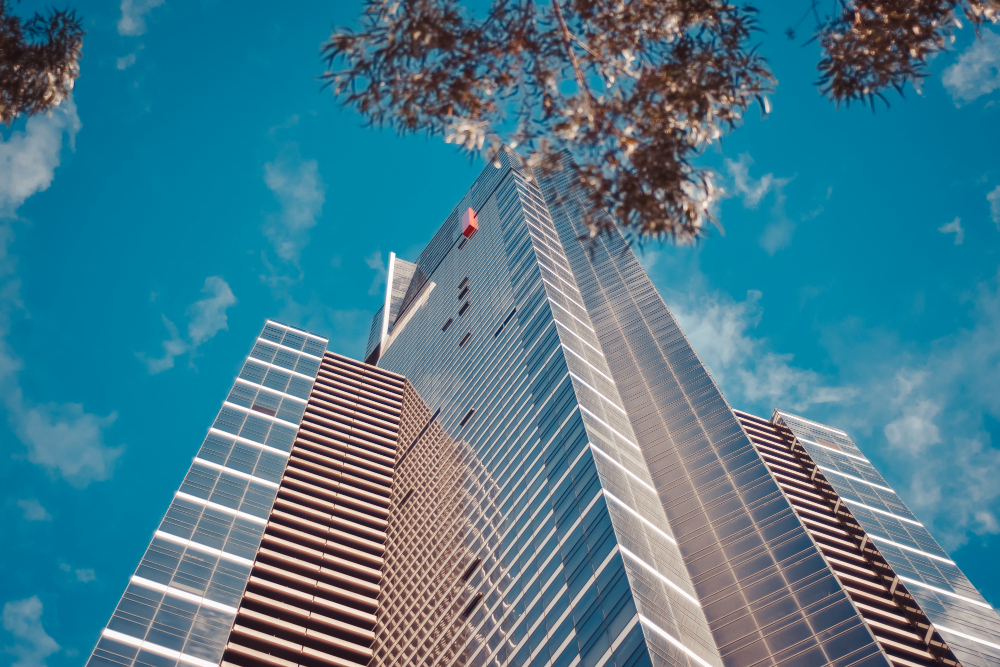 Low angle shot of a tall business building with a blue cloudy sky