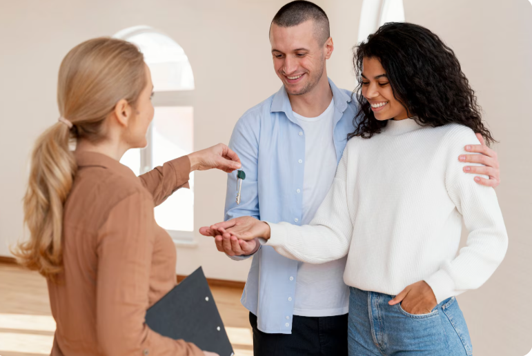 Close-up of woman's hand giving house key to man over wooden table 