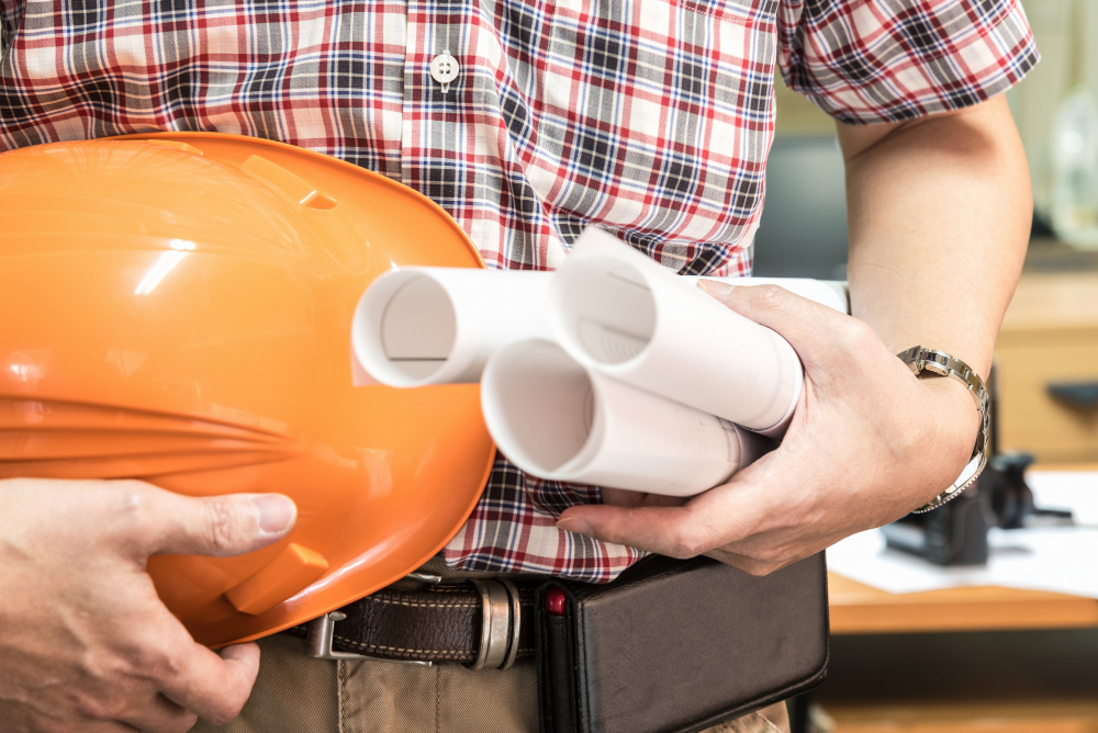 Young architect holding blueprint and hamlet
