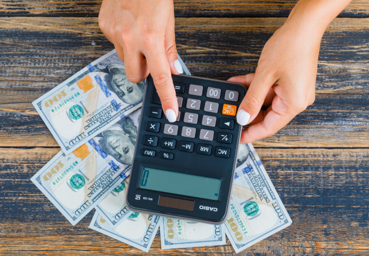 Close-up woman using calculator 