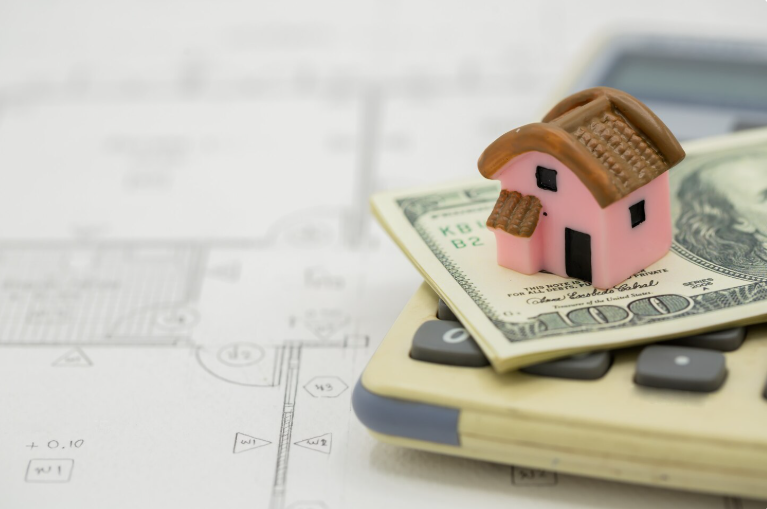 House on the calculator with dollar bills 