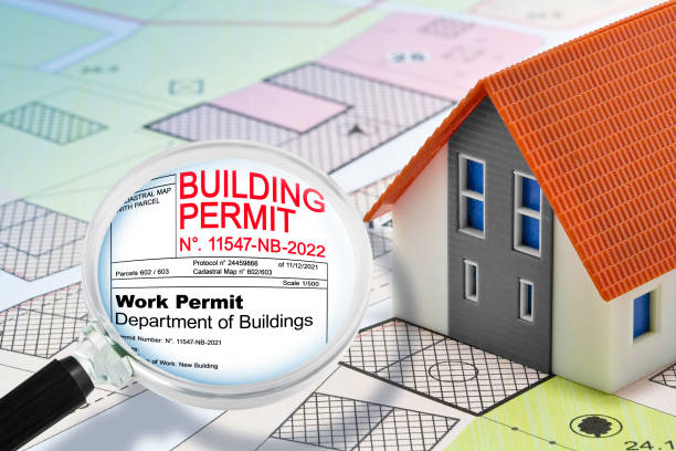 REAL ESTATE AND CONSTRUCTION INDUSTRY CONCEPT WITH BUILDING PERMIT, General Urban Plan, home model and magnifying glass