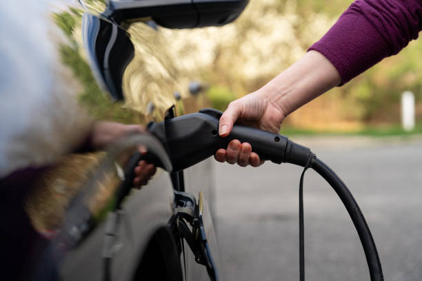 Latin woman charging an electric vehicle at home