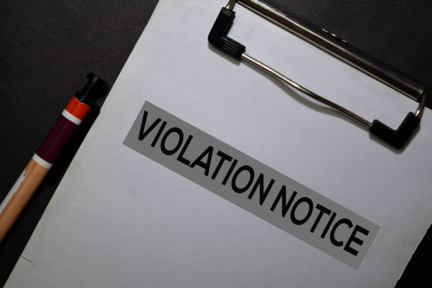 Violation Notice write on a paperwork isolated on black table.