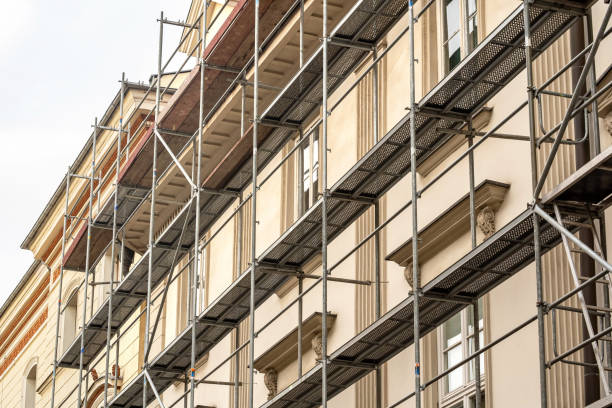 Scaffolding on a generic old tenement house, renovated historical building facade detail, closeup, nobody. Restoration industry, old architecture, real estate renovation simple concept, no people