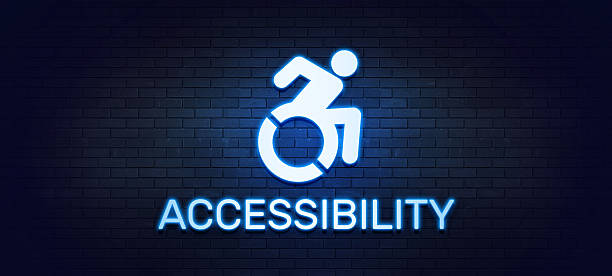 A glowing blue neon sign with the word "ACCESSIBILITY" and the modern wheelchair symbol. This powerful visual, set against a dark brick wall, clearly indicates accessible facilities and promotes a message of disability inclusion and equality. It is an ideal graphic for public spaces, businesses, and campaigns focused on disability rights and creating an inclusive environment for all.