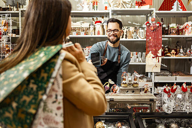Friendly shop assistant helping woman with shopping