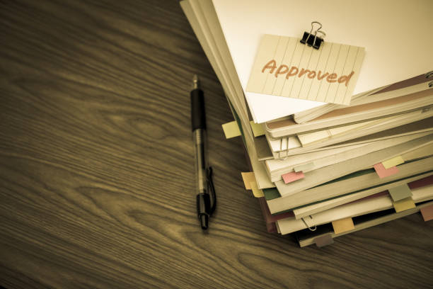 Approved; The Pile of Business Documents on the Desk