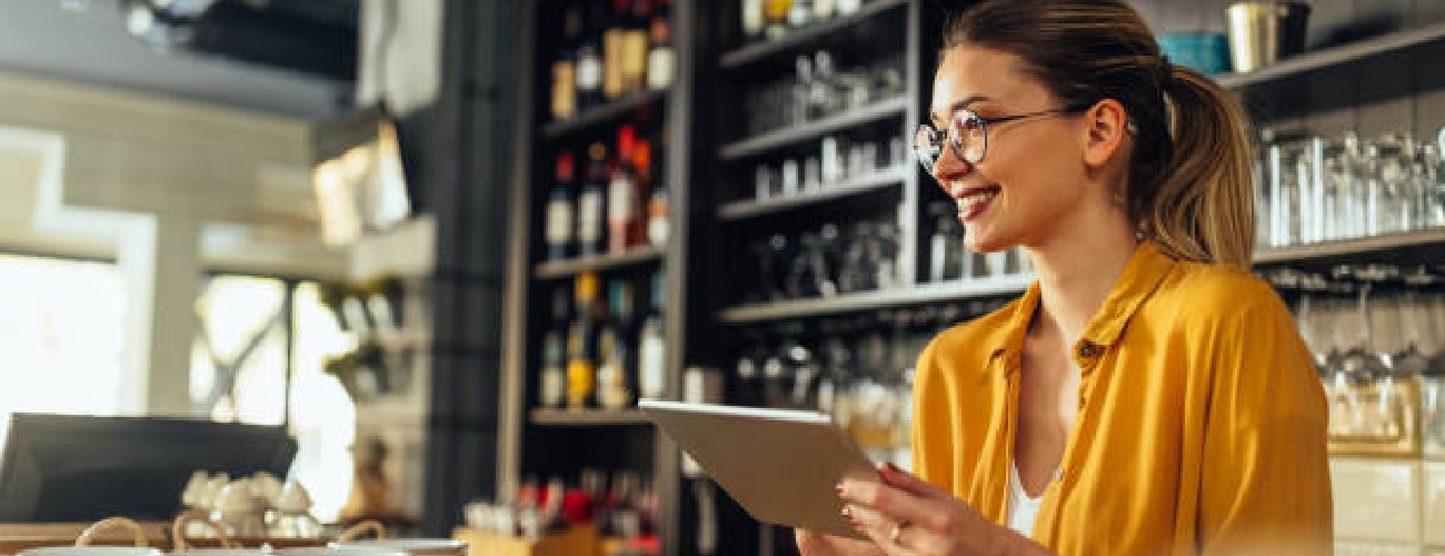 grok-image-ab52af73-db30-483b-82be-a63ed86fc5e0 Young woman using a digital tablet while working in a coffee shop