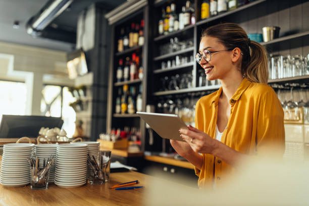Young woman using a digital tablet while working in a coffee shop